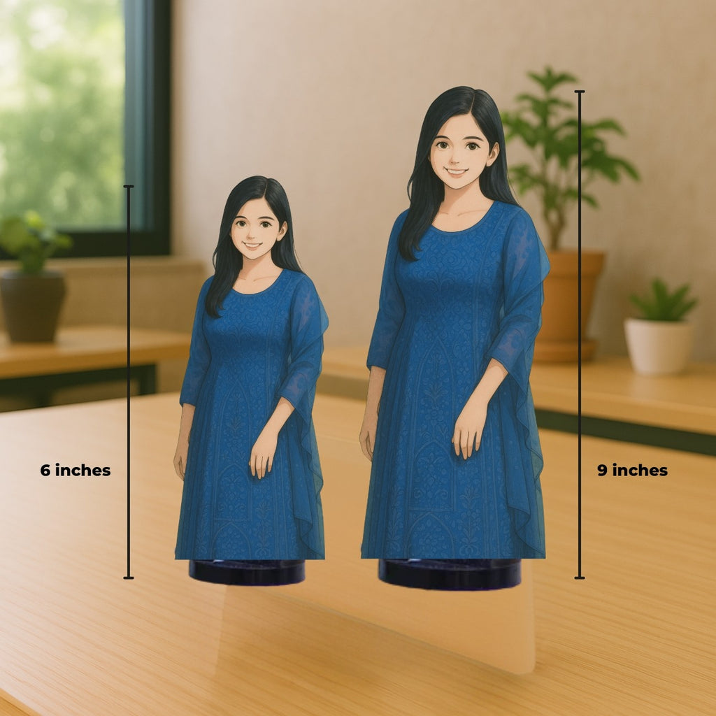 Two cutouts of a smiling character in a blue dress are on a wooden table. One is 6 inches and the other 9 inches tall. Background has plants and a window.